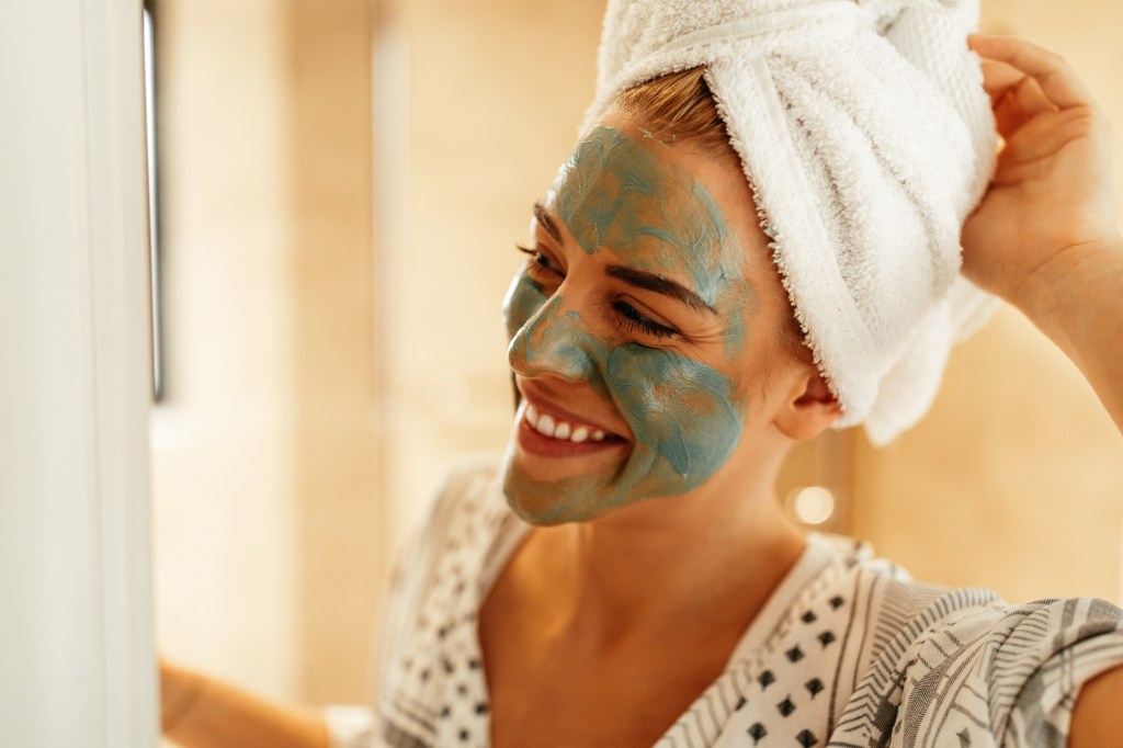 mulher usando máscara facial em creme Cuidados na quarentena: como tratar pele, cabelo, unhas e barba