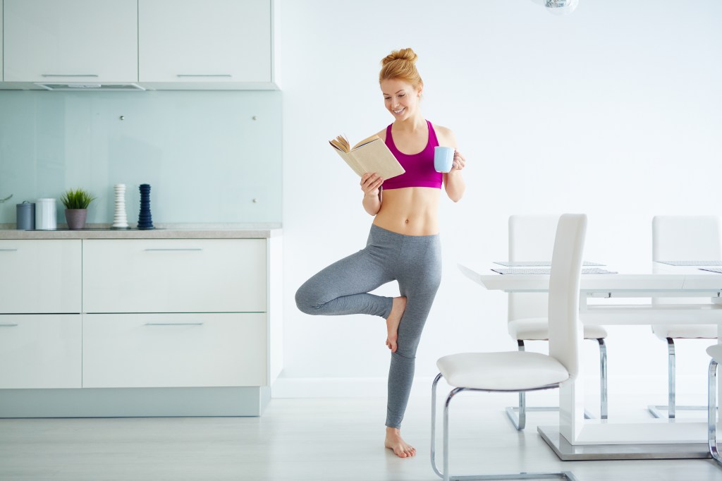 Mulher com roupas de ginástica lendo livro