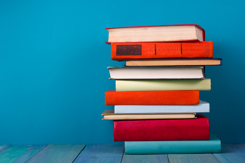 Stack of colorful books, grungy blue background, free copy space Como revisar Ciências Humanas para o Enem