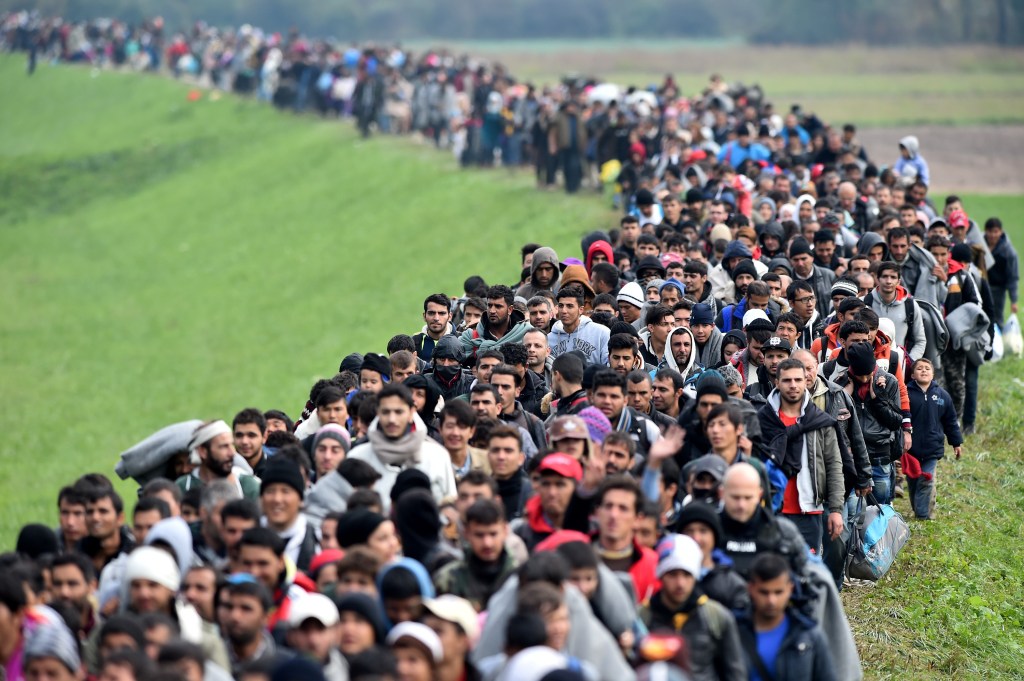 RIGONCE, SLOVENIA - OCTOBER 23:  Migrants are escorted through fields by police as they are walked from the village of Rigonce to Brezice refugee camp on October 23, 2015 in Rigonce,, Slovenia. Thousands of migrants marched across the border between Croatia into Slovenia as authorities intensify their efforts to attempt to cope with Europe's largest migration of people since World War II.  (Photo by Jeff J Mitchell/Getty Images)