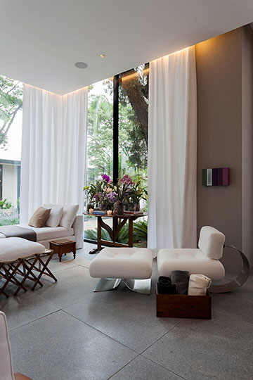 CASACOR SP: Living com biblioteca, espaço de leitura e jardim de inverno