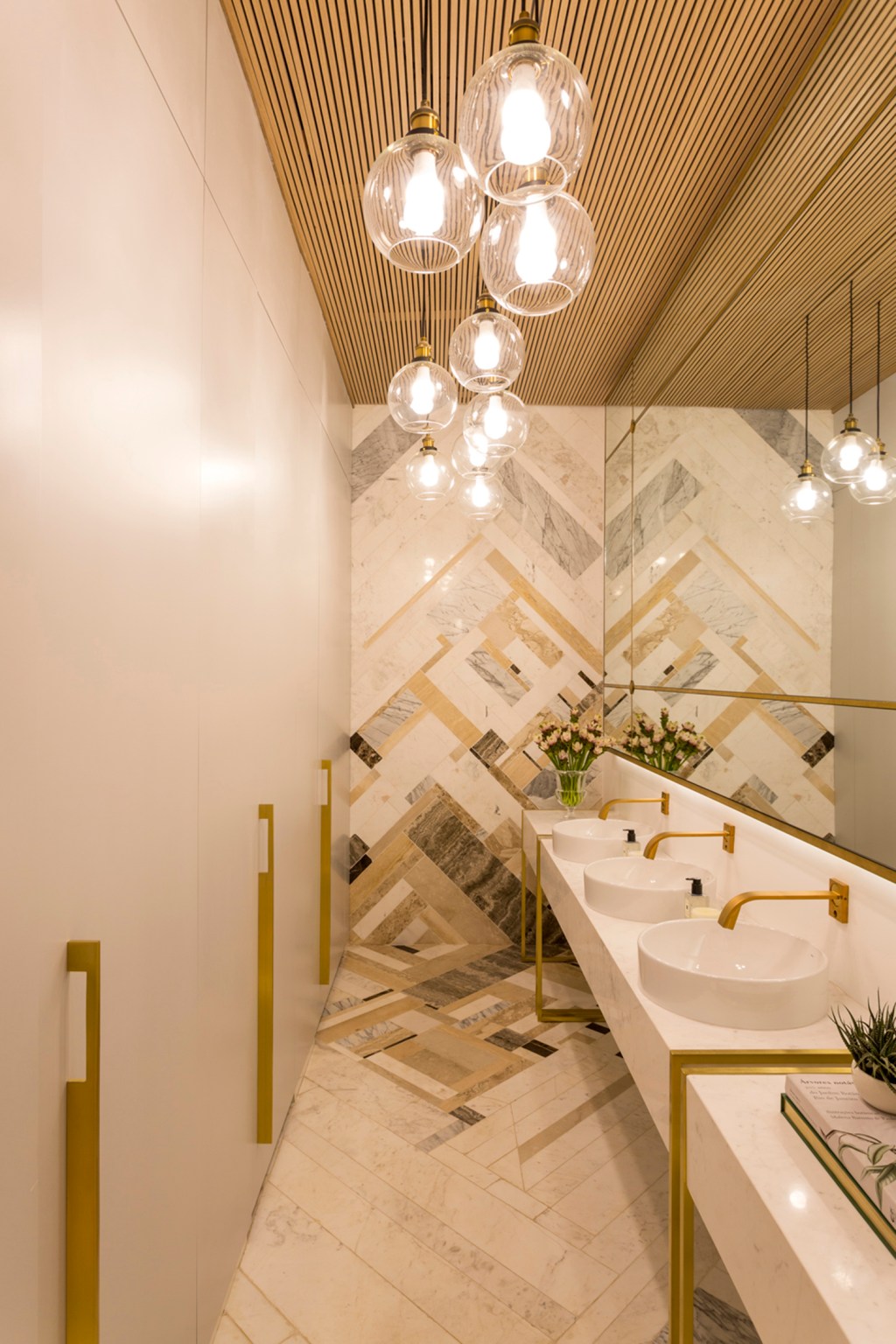 Aparas de mármore revestem parede e piso de banheiro na CASACOR SP